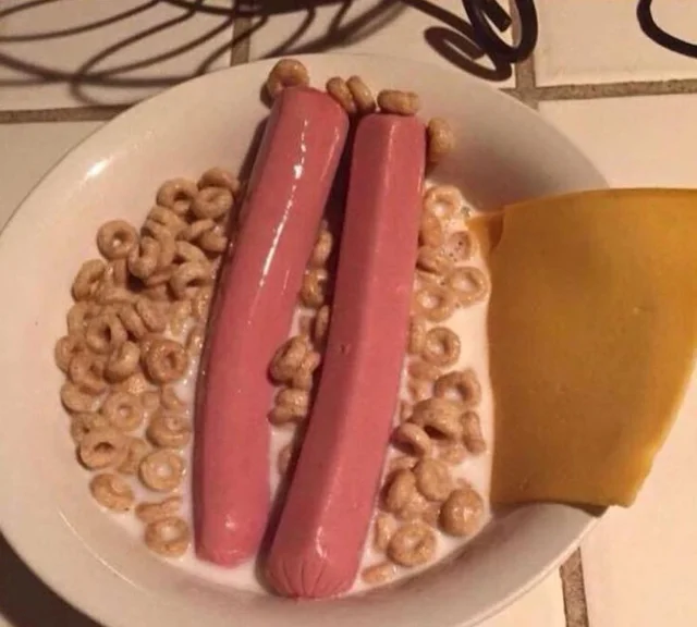 Cereal with a slice of cheese and hot dog in it.